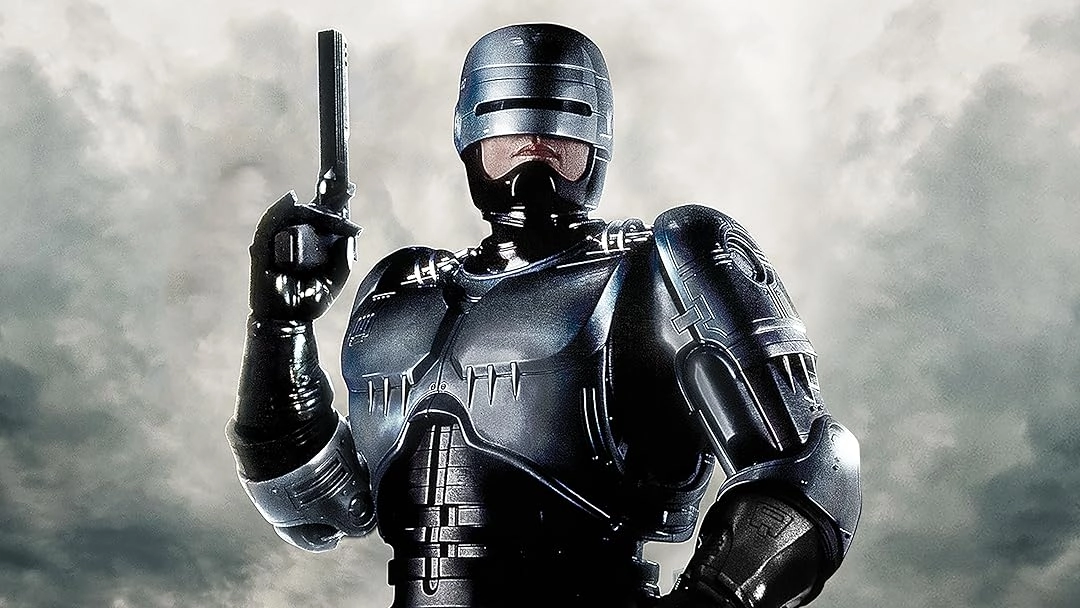 Futuristic armored cyborg in black suit raises a pistol against a cloudy sky.