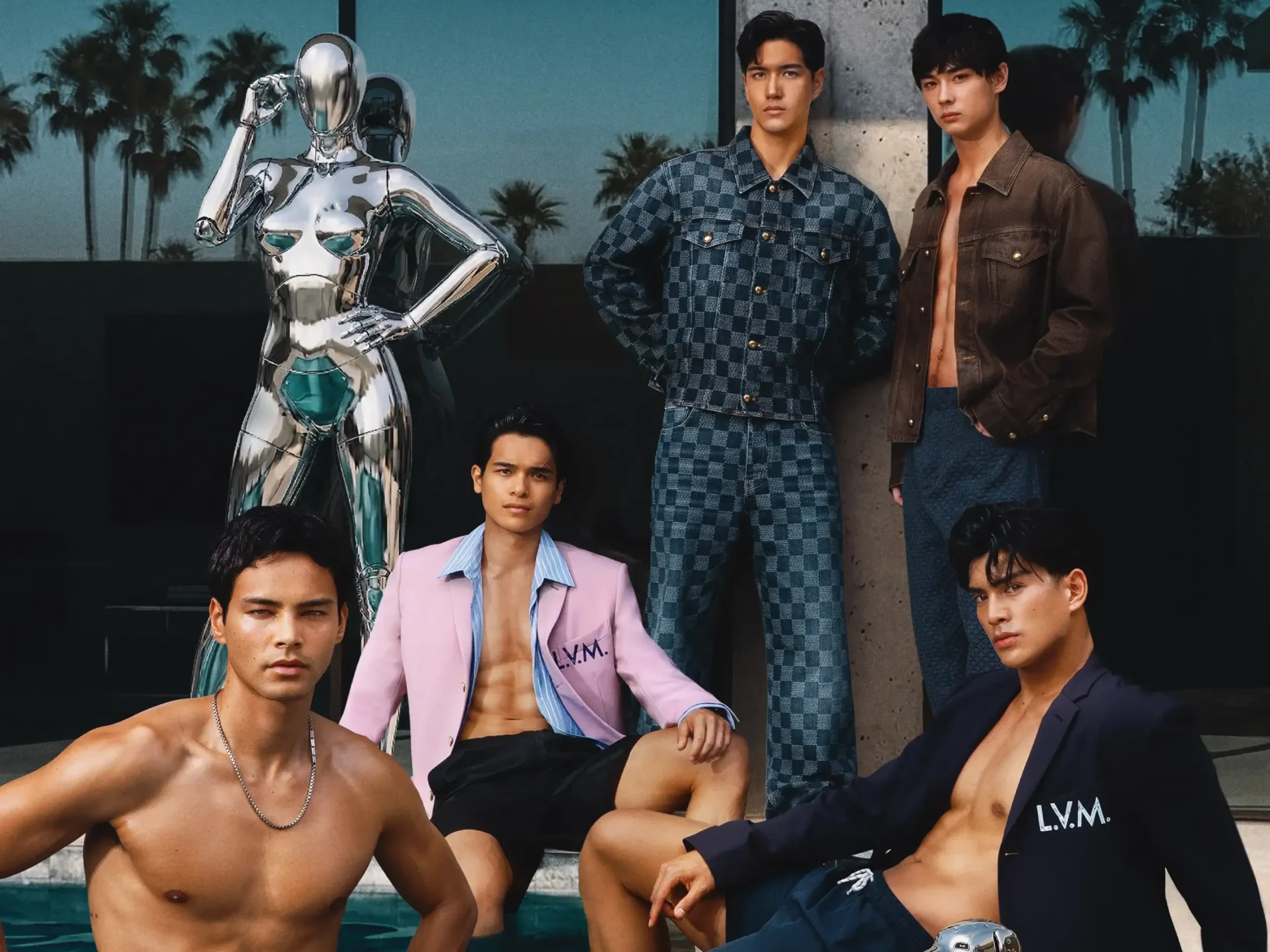 Group of male models posing with a reflective chrome robot statue outdoors.