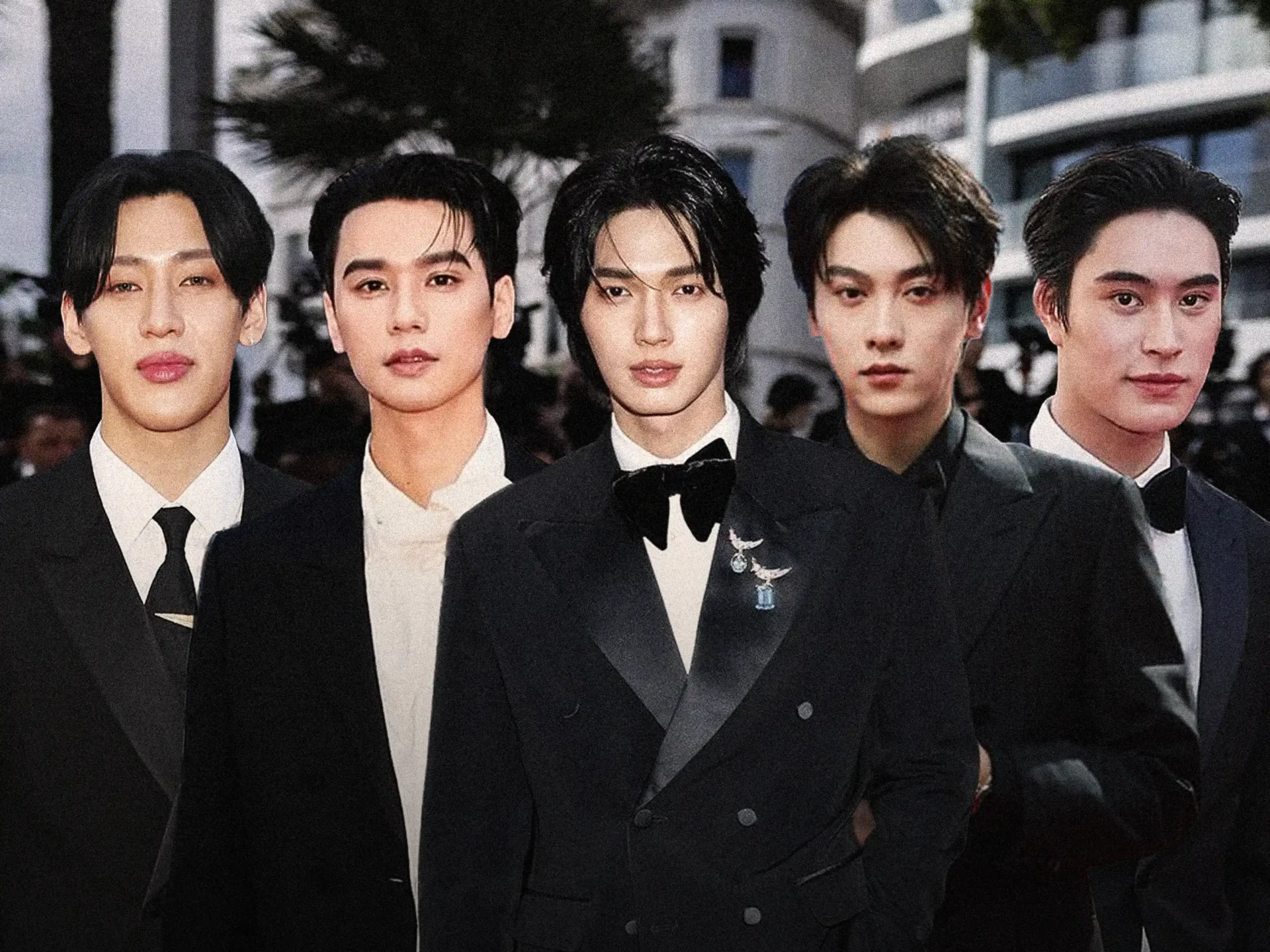 Five young men in black tuxedos pose together at a formal event on a red carpet or gala.
